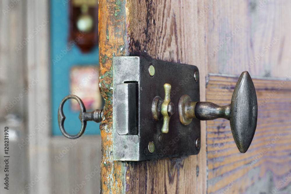 Old lock and key in a wooden door Old lock and key in a wooden door