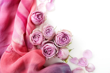 Framework from roses and silk on white background. Flat lay. Top view