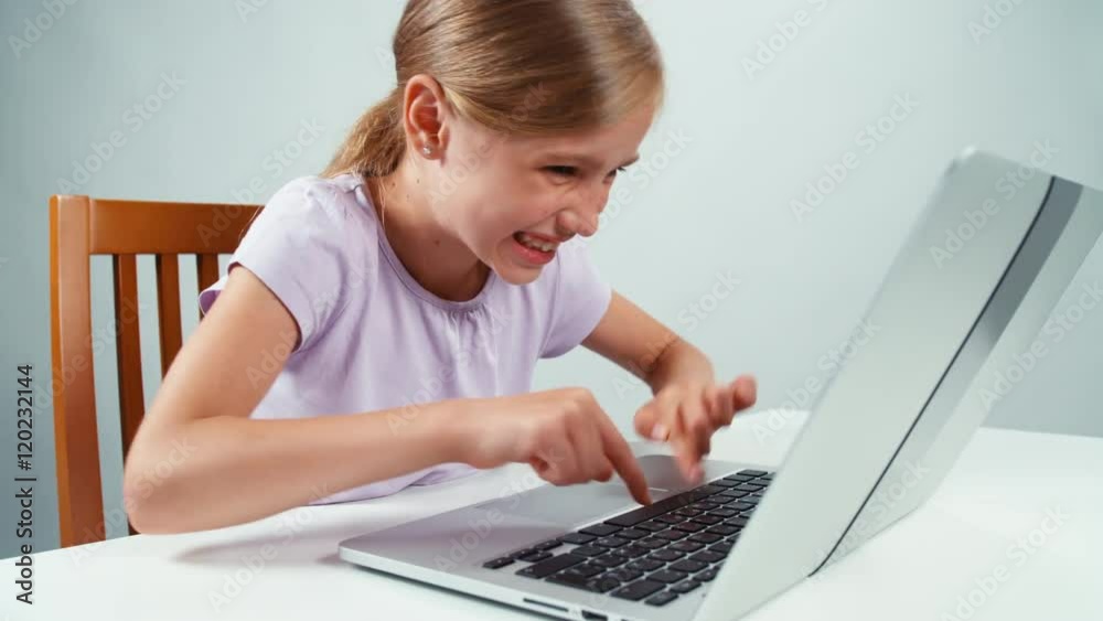 Extreme closeup child girl smiling at camera with teeth and something typing in laptop Extreme closeup child girl smiling at camera with teeth and something typing in laptop