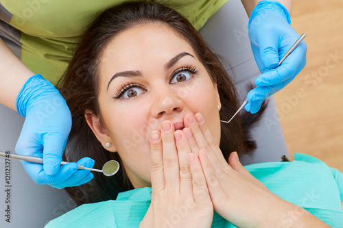 Foto Concept phobia dentist, dental office. Young girl at the dentist