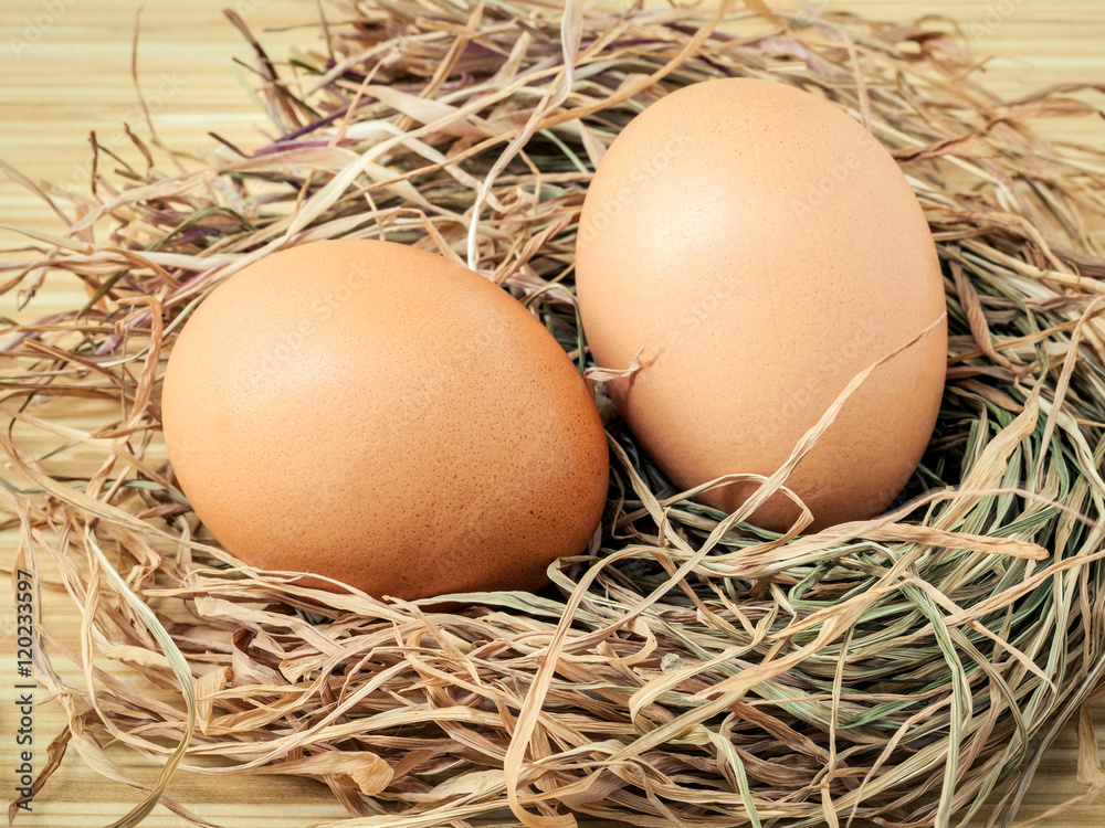 Closeup brown chicken eggs in a straw nest . Fresh organic eggs Closeup brown chicken eggs in a straw nest . Fresh organic eggs