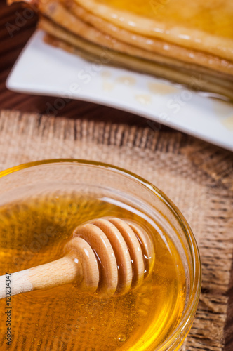 Fresh honey with a Stack of blinis or crepes