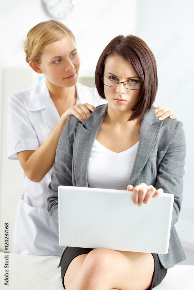 Masseur massaging a young businesswoman while she is working Masseur massaging a young businesswoman while she is working