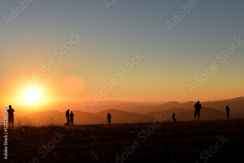 People relaxing and enjoying sunset in the mountains