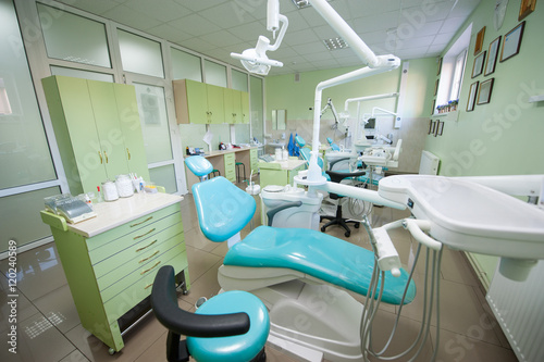 Contemporary empty dental office with three dental chairs and equipment