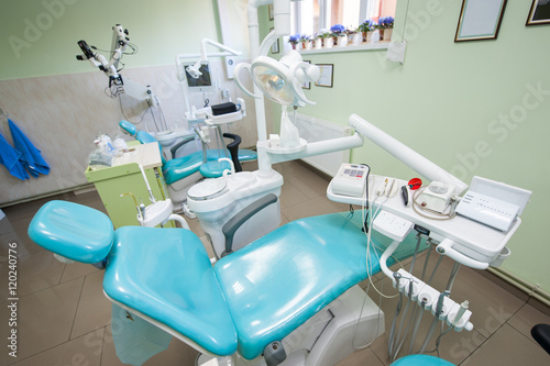 Modern dental chair with accessories to it  drill  photopolymer lamp  equipment for restorative dentistry in dentist s office