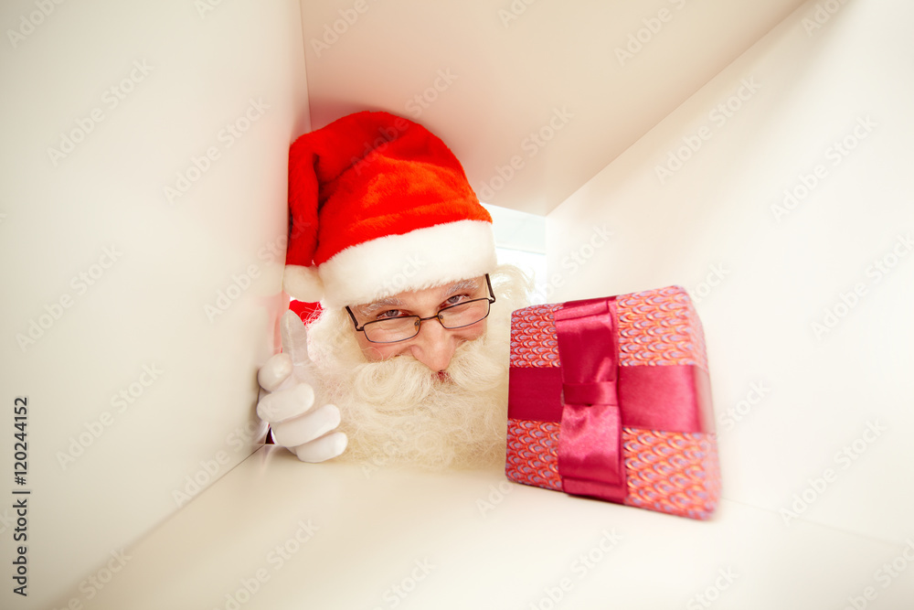 Fototapeta premium Santa face with gift box in chimney