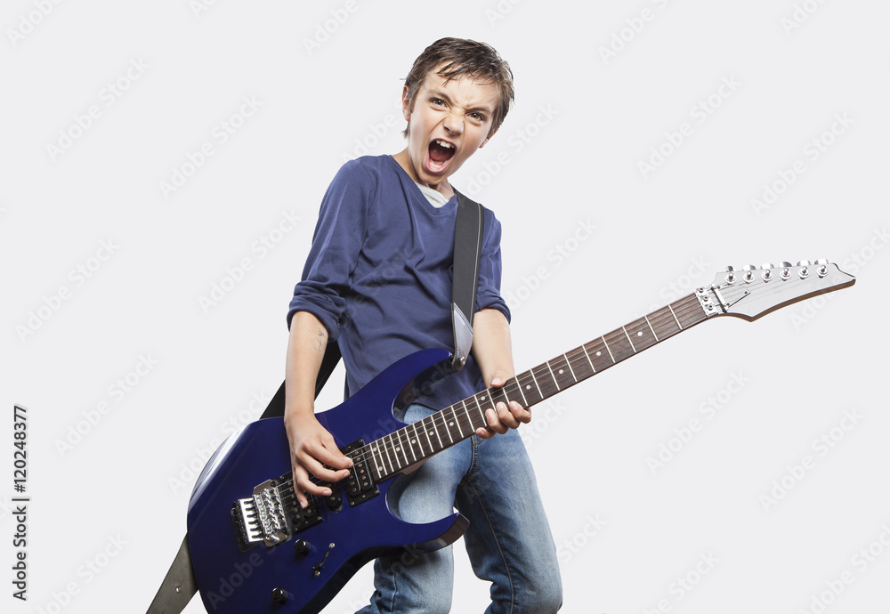 Portrait of adorable young boy playing electric guitar. Rock and Portrait of adorable young boy playing electric guitar. Rock and