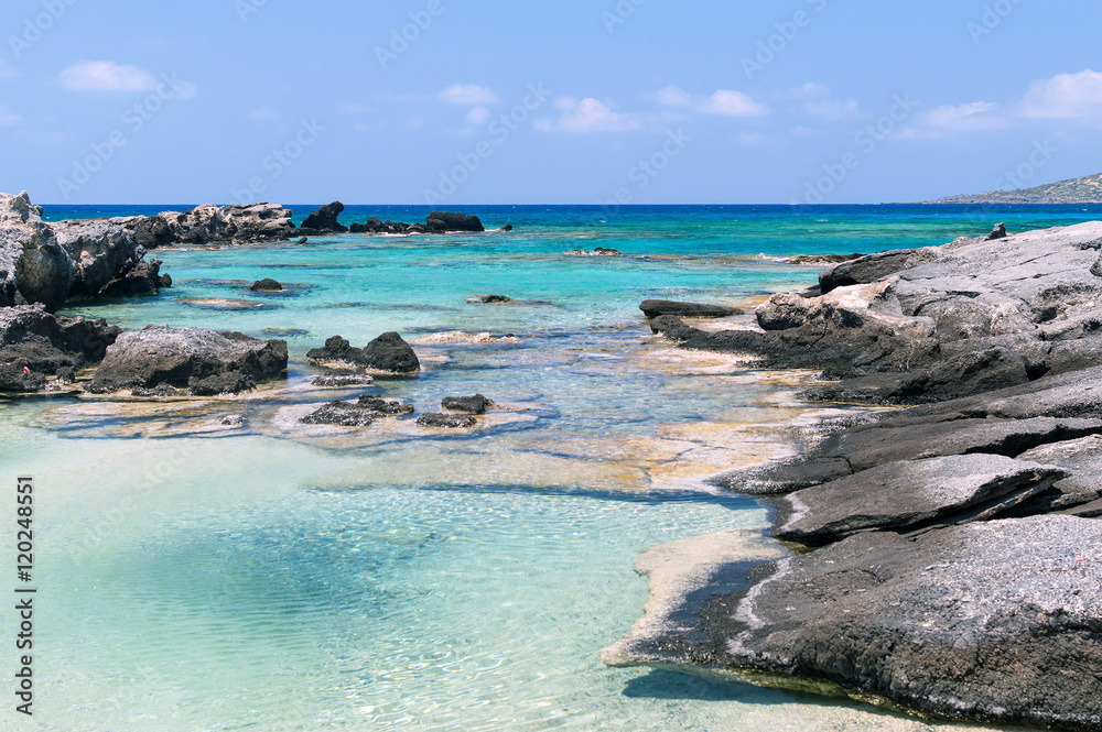 Rocky wild beach with azure clear color water