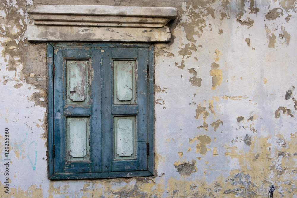 Old wood window in blue color on old wall.