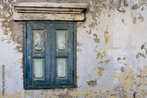 Old wood window in blue color on old wall.