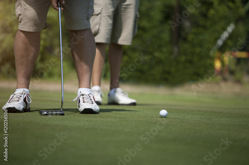 Men golfing on green