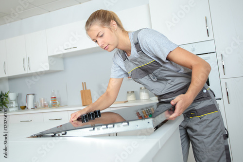 Foto Woman fitting ceramic hob into kitchen