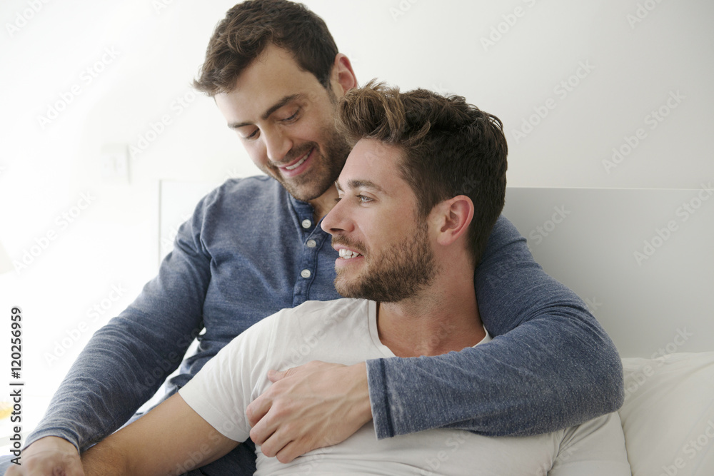 Gay Male Couple At Home Relaxing In Bed Together Gay Male Couple At Home Relaxing In Bed Together