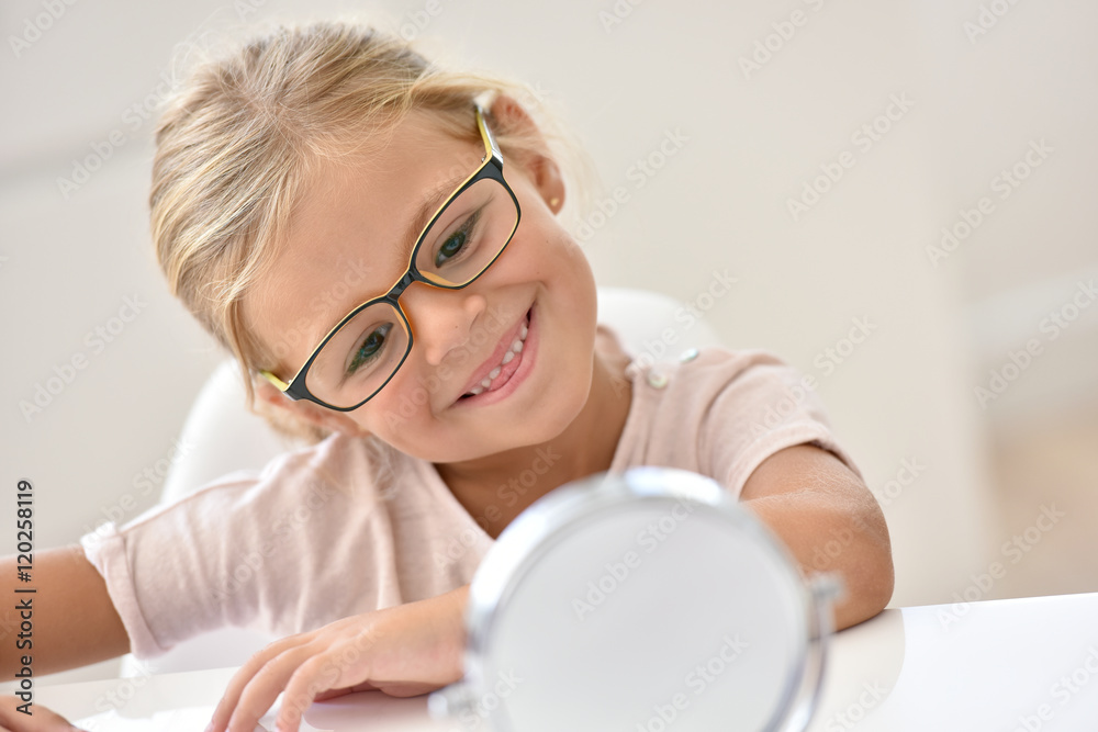 © goodluz - Little girl at the optician trying different eyeglasses © goodluz - Little girl at the optician trying different eyeglasses