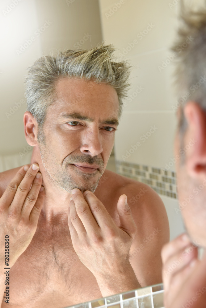 Fototapeta premium Mature man in bathroom checking beard