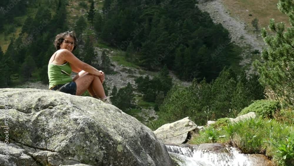 hiker woman rests on a rock in the mountains hiker woman rests on a rock in the mountains