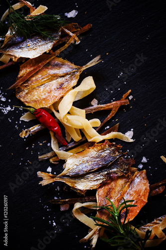 Unhealthy food background: dried fish, smoked squid, spices. Sal
