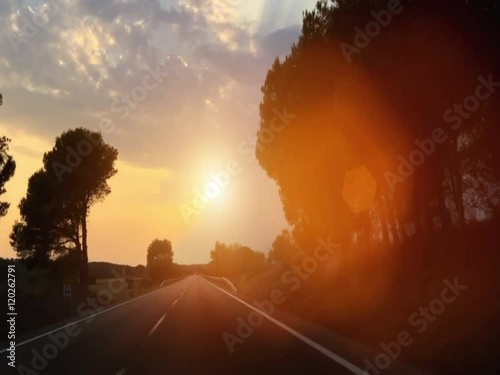  car driving on a country road in the sunset  photo