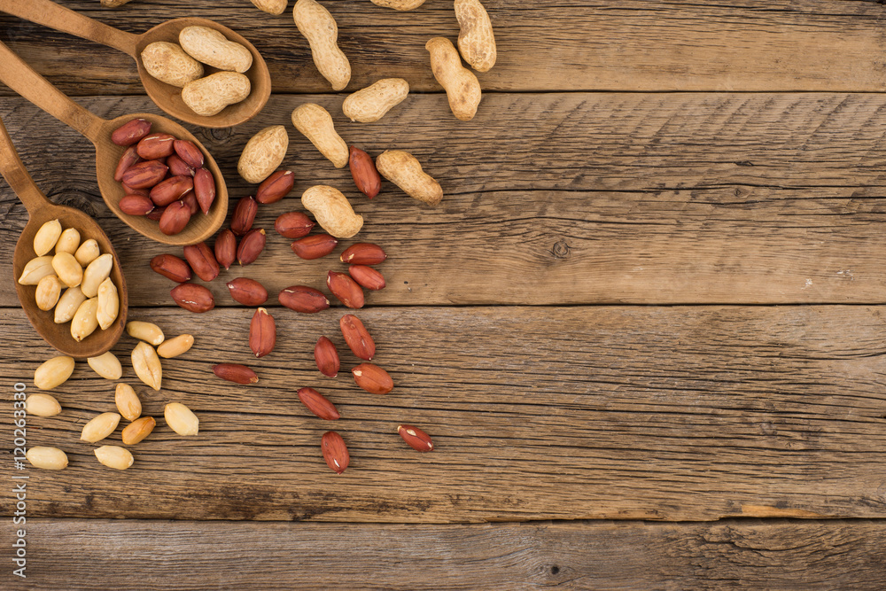 Peanuts in wooden spoons on an old wooden background. Peanuts in wooden spoons on an old wooden background.