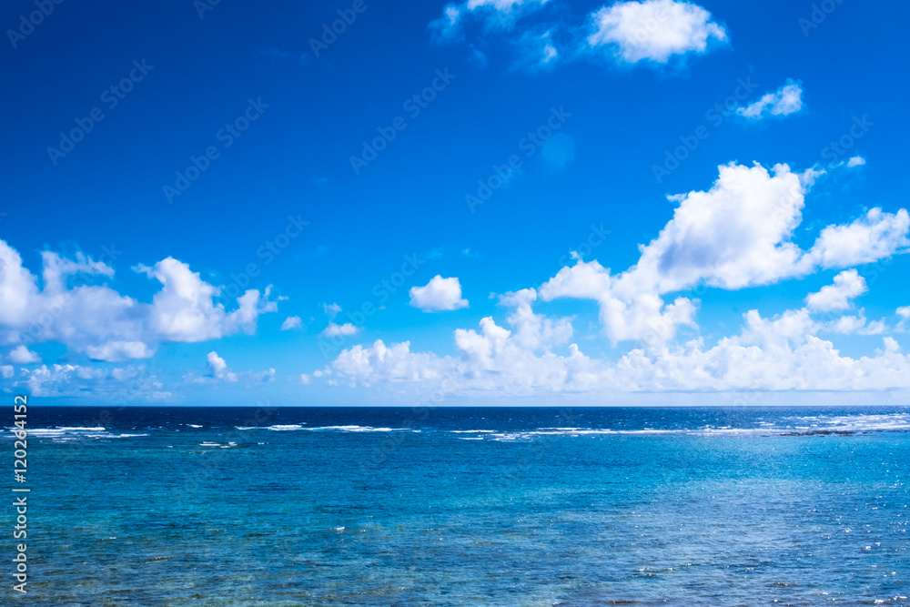 日差しの中の沖縄の青い海と輝く雲