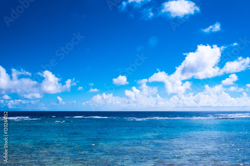 日差しの中の沖縄の青い海と輝く雲