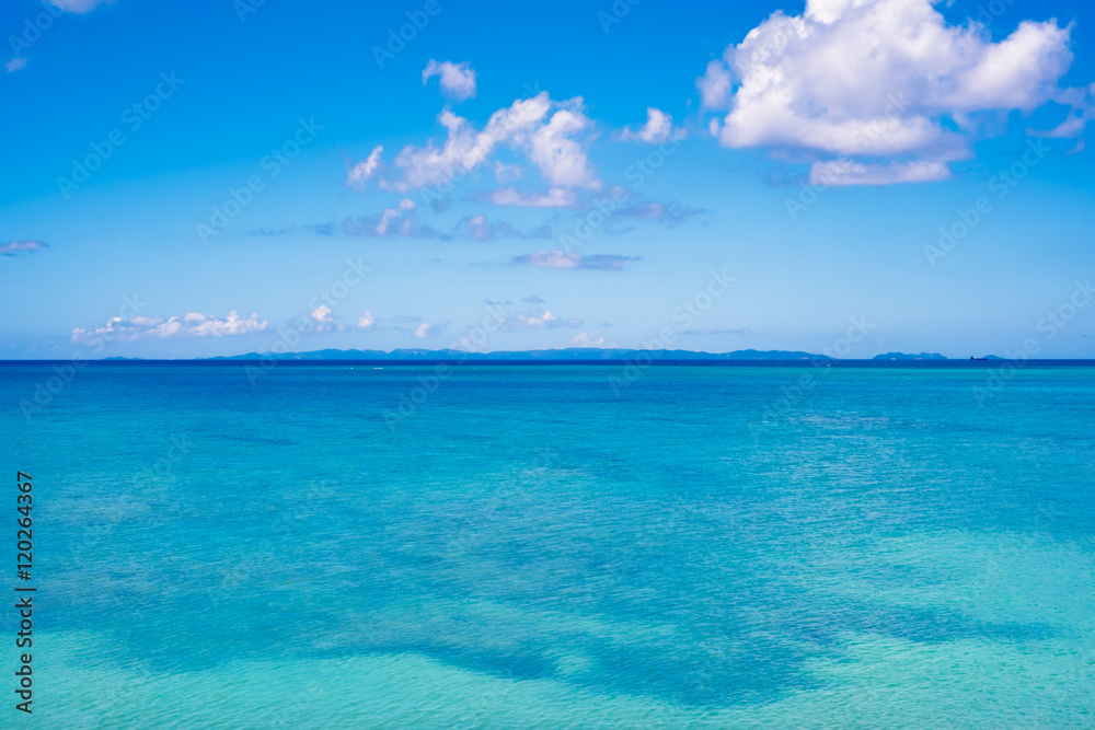 沖縄の静かなエメラルドグリーンの海と浮かぶ