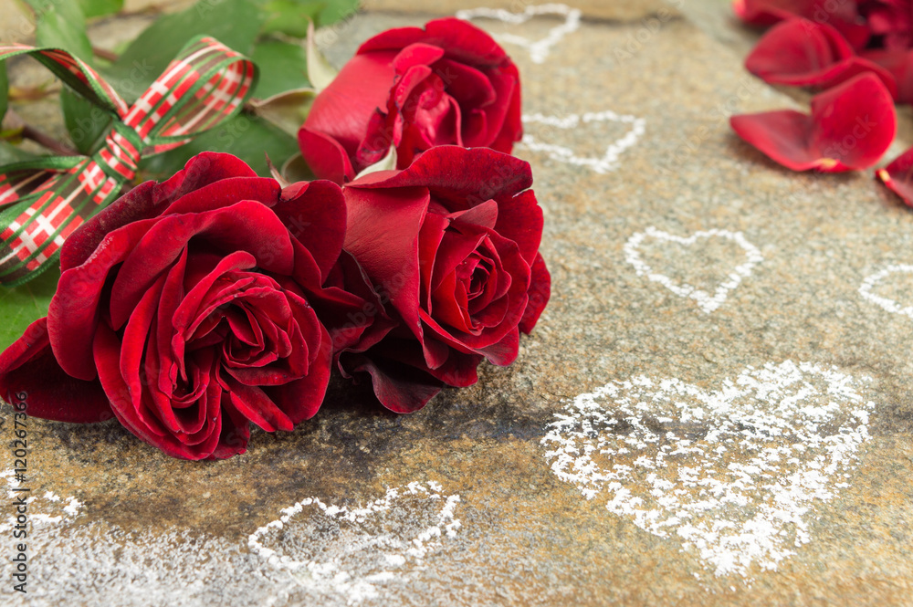Obraz premium Red roses bouquet with ribbon on stone table