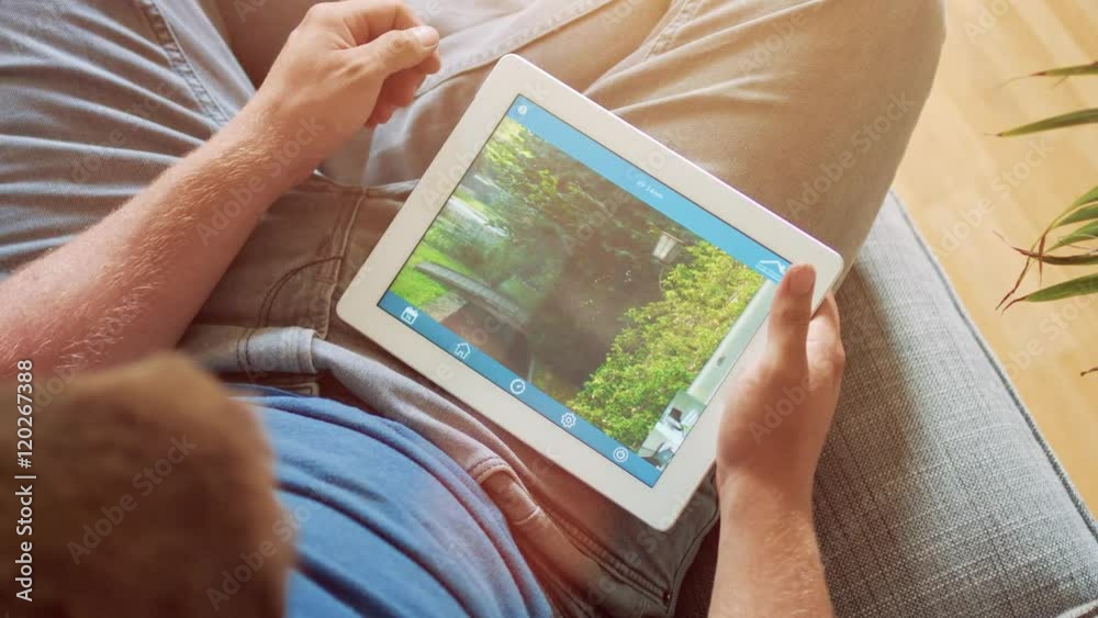 smart house, home automation, device with app icons. Man uses his tablet PC with smarthome app to control his house. the new generation of the internet of things.