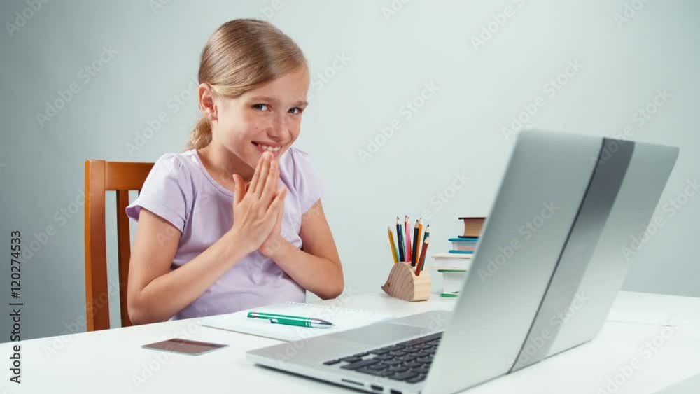 Portrait student girl 7-8 years looking with big eyes at laptop. Child has surprise. Thumbs up. Ok Portrait student girl 7-8 years looking with big eyes at laptop. Child has surprise. Thumbs up. Ok