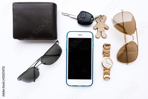 Top view of lady set: watches,camera, car keys, sunglasses,and smartphone on white background
