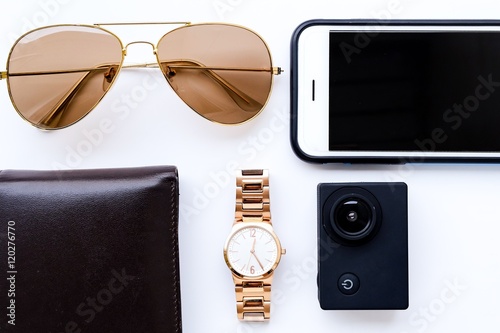 travel set: watches,camera,wallet,sunglasses,and smartphone on white background

