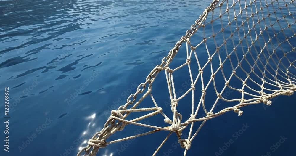 Yacht bow with netting on a calm summer day on the sea