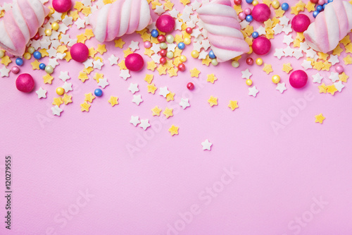 Sweets and candies on pink background with copy space