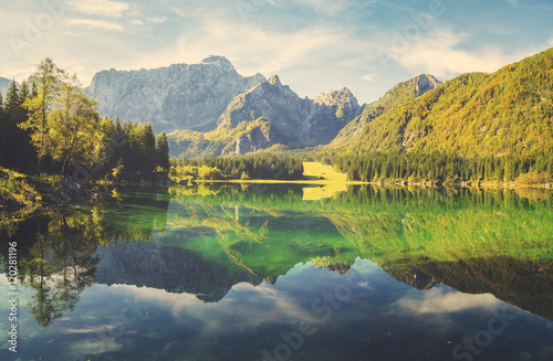 Alpine lake at dawn, beautifully lit mountains, retro colors, vintage 