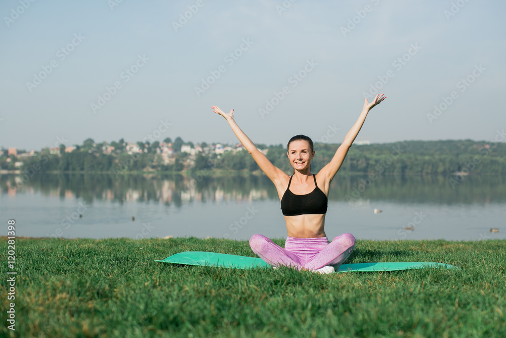 Young woman doing yoga in morning park near lake Young woman doing yoga in morning park near lake
