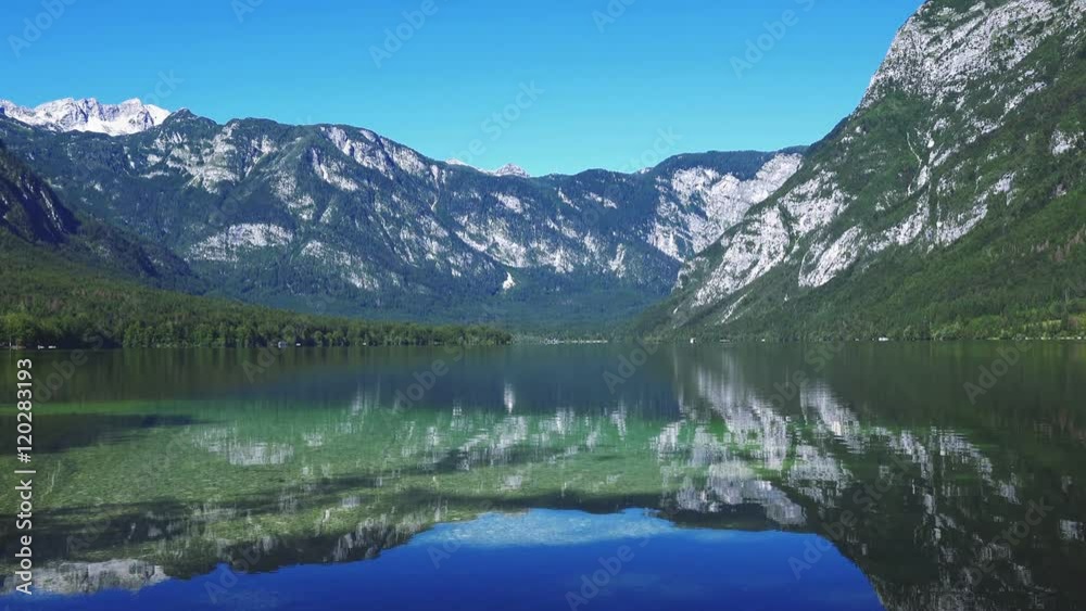 Bohinj lake in Slovenian national park Triglav with its clear water surface surrounded with Julian Alps mountains Bohinj lake in Slovenian national park Triglav with its clear water surface surrounded with Julian Alps mountains