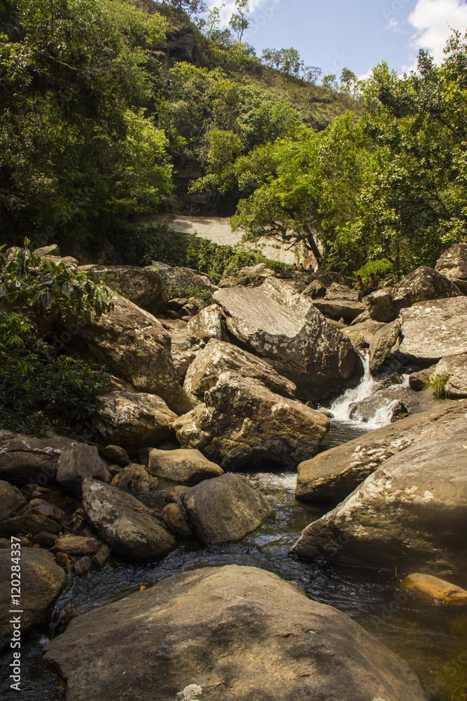 Water falls between rocks in sunny day - Serra da Canastra Natio