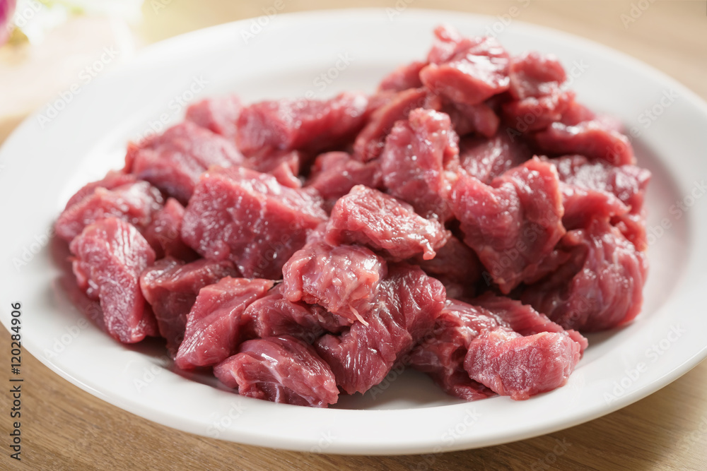 raw fresh sliced beef for beefsteaks in plate on kitchen table