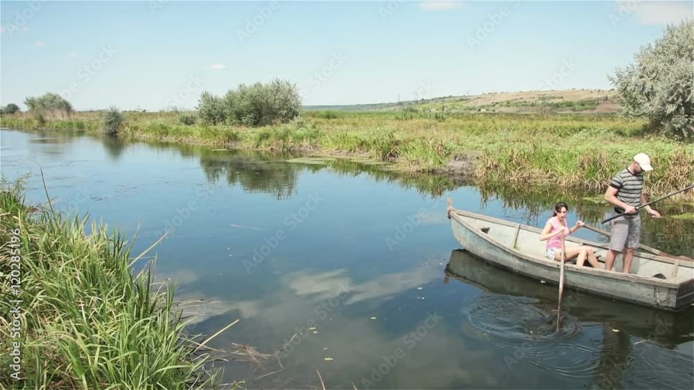 Fisherman on boat throws the bait and the girl rowing oars Fisherman on boat throws the bait and the girl rowing oars