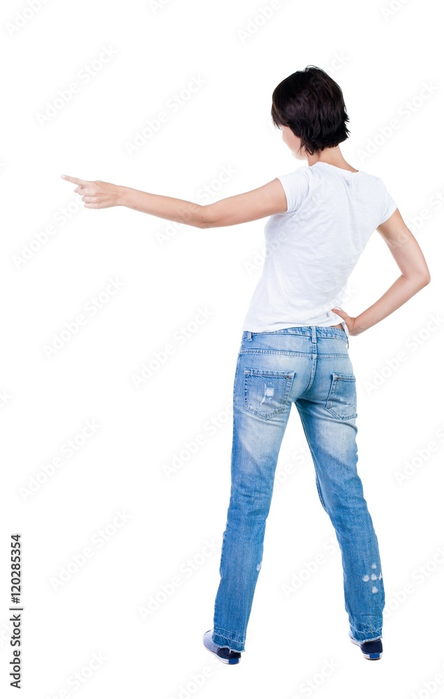 Back view of young brunette woman pointing at wall. beautiful girl. Rear view people collection. backside view of person. Isolated over white background. Back view of young brunette woman pointing at wall. beautiful girl. Rear view people collection. backside view of person. Isolated over white background.