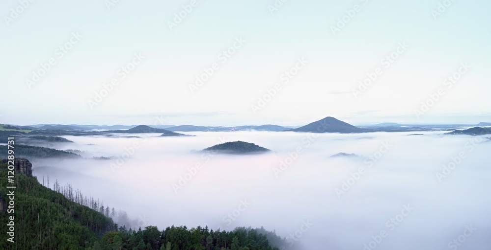 Magnificent heavy mist in landscape. Autumn creamy fog in countryside. Hill increased from fog,