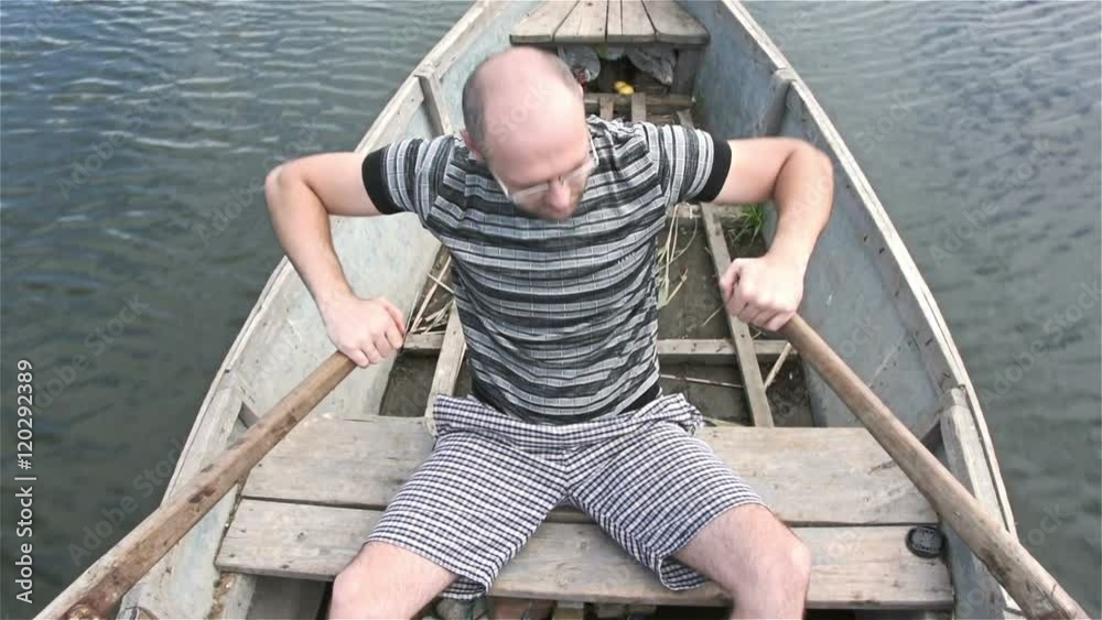 Fisherman floats on a makeshift boat on a long river. Slowmotion Fisherman floats on a makeshift boat on a long river. Slowmotion