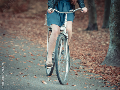 Lady cycling in park. © Voyagerix