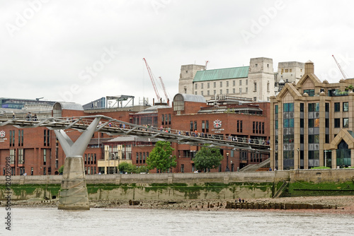 Tourists crossing the Millennium Bridge linking the City of London with the South Bank between St Paul Cathedral and Tate Modern art gallery.