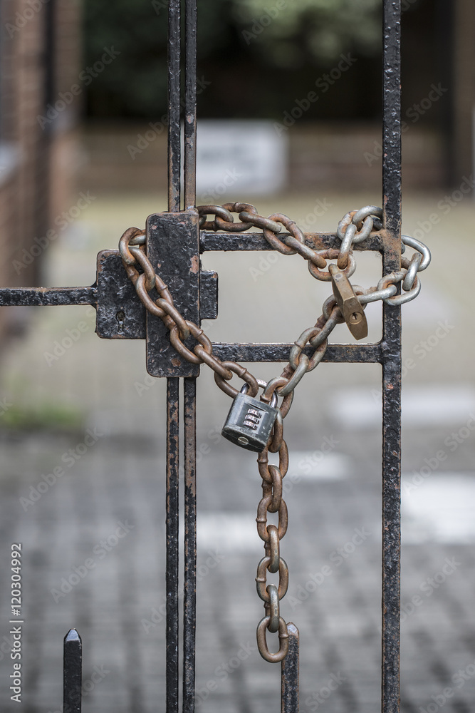 A locks and chains on two metal gates A locks and chains on two metal gates