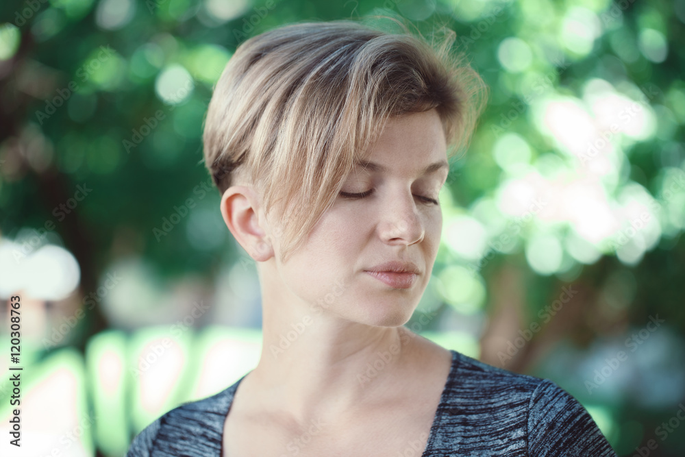Closeup portrait of smiling young middle aged white caucasian girl woman  with short hair stylish haircut in tshirt with closed eyes outside in  summer park, beauty fashion lifestyle Stock Photo
