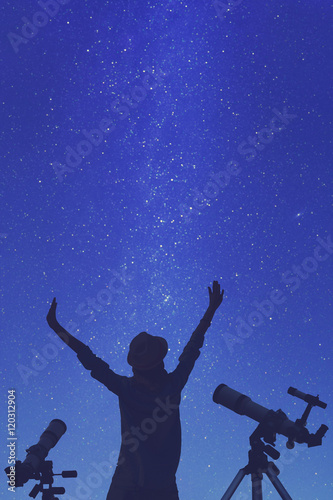 Girl enjoying starry skies with telescopes beside her. 