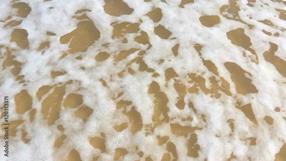 Close up of ripples and rolling waves on a sandy beach, handheld. Close up of ripples and rolling waves on a sandy beach, handheld.
