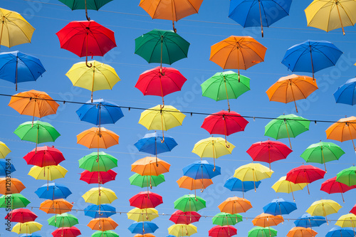 multicolored umbrellas row in blue sky